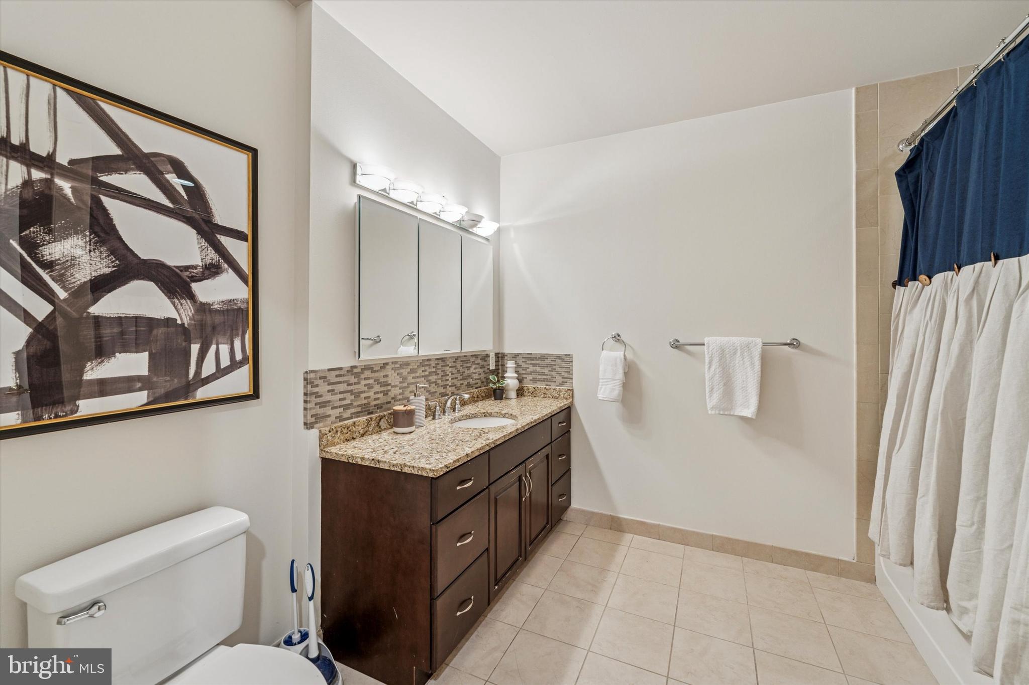 1600 Arch Street, Unit 1706 Philadelphia, PA 19103 - Photo 16 of 34 a bathroom with a granite countertop sink a toilet and a shower