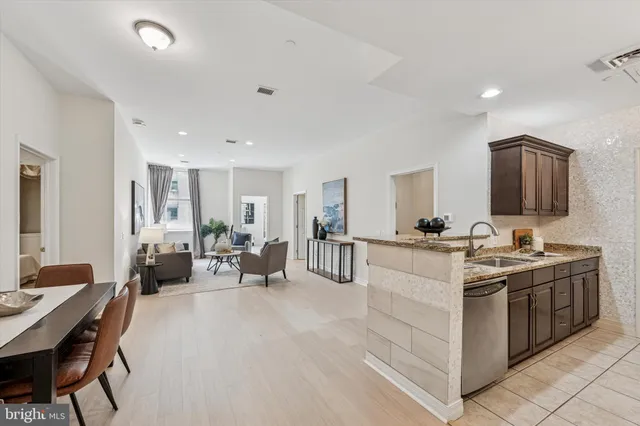 a large white kitchen with a stove a sink a dining table and chairs