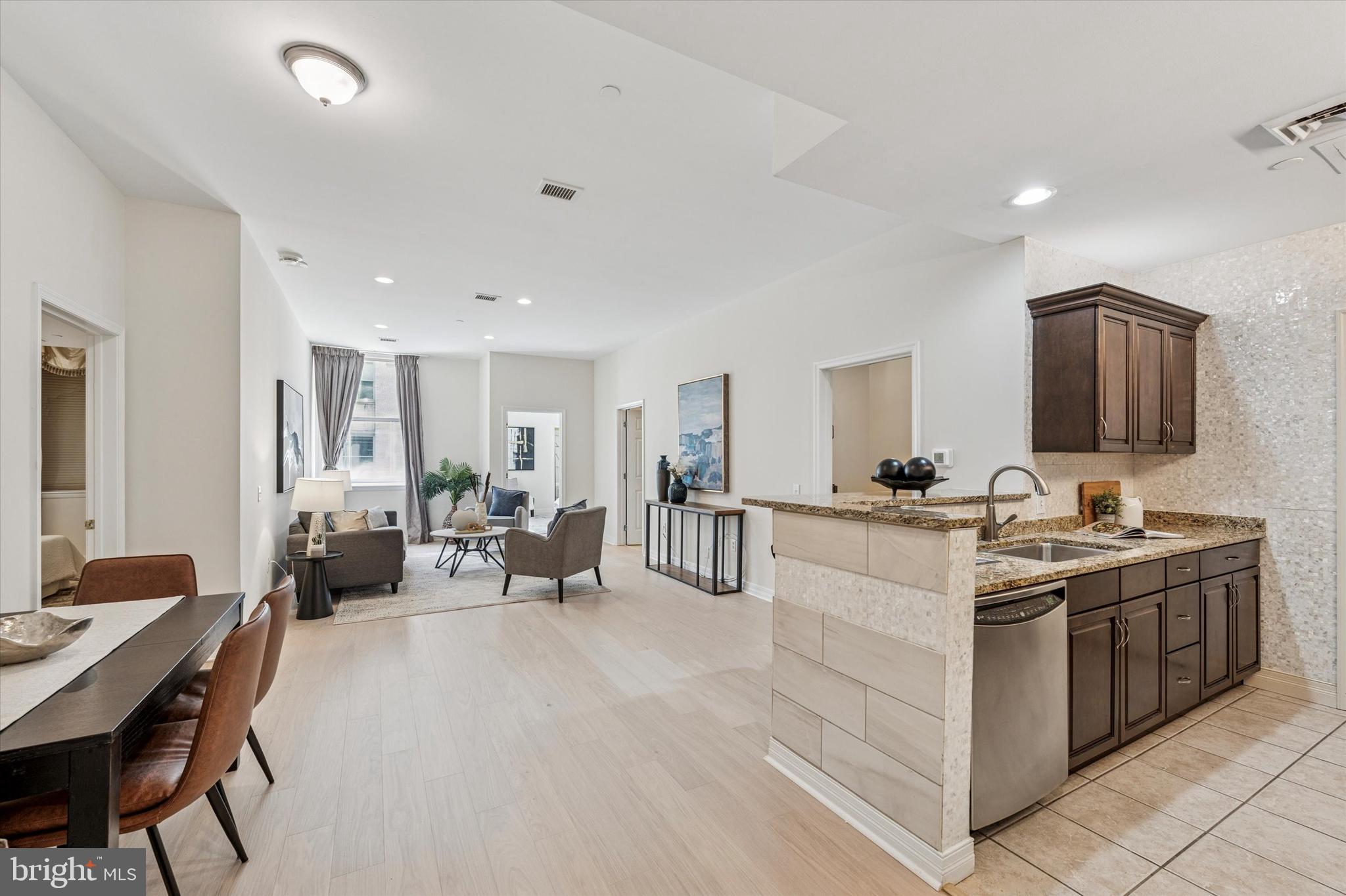 1600 Arch Street, Unit 1706 Philadelphia, PA 19103 - Photo 4 of 34 a large white kitchen with a stove a sink a dining table and chairs