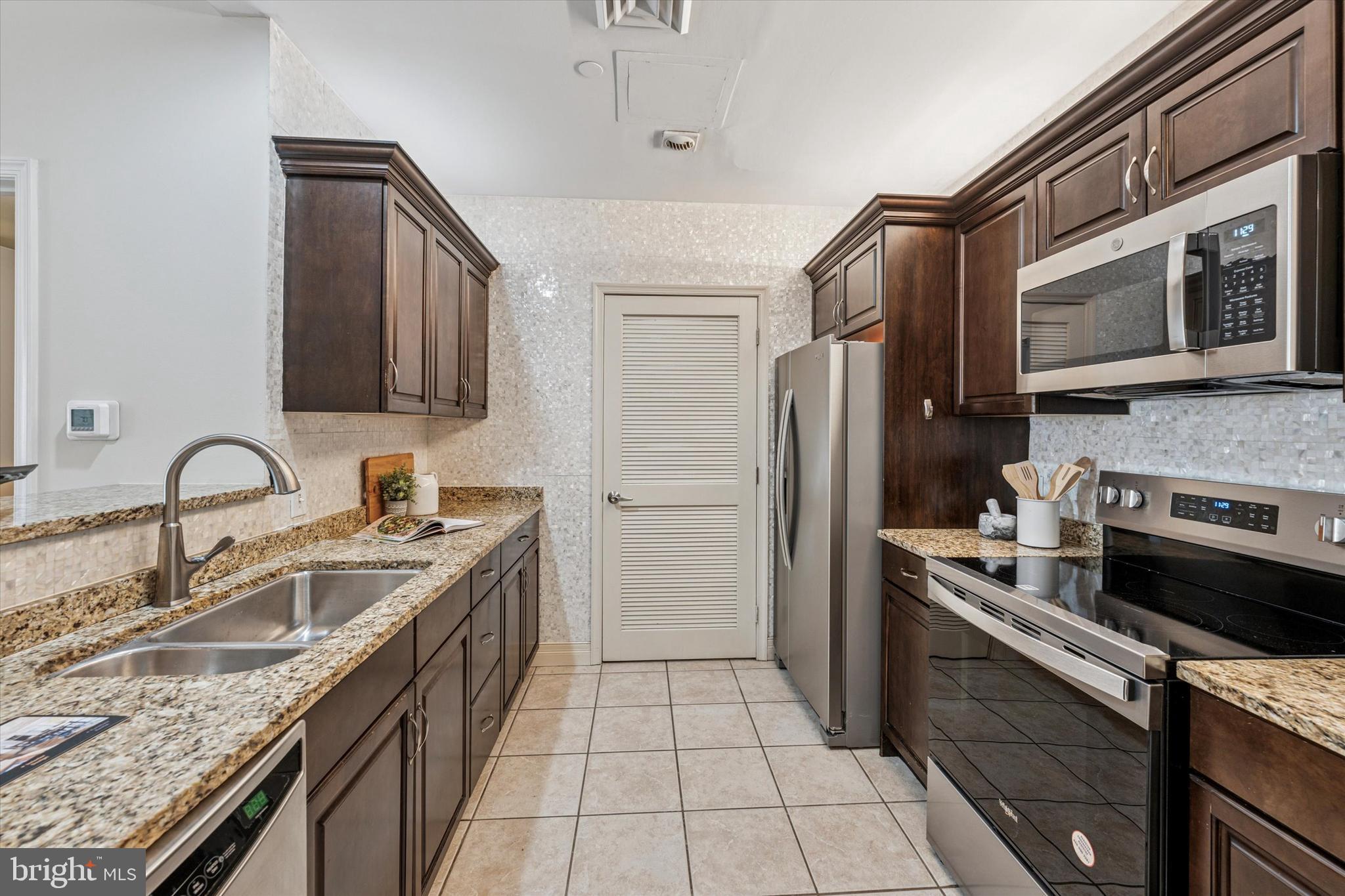 1600 Arch Street, Unit 1706 Philadelphia, PA 19103 - Photo 5 of 34 a kitchen with stainless steel appliances granite countertop a sink stove and refrigerator