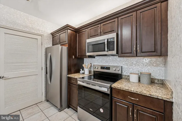 a kitchen with granite countertop stainless steel appliances and wooden cabinets