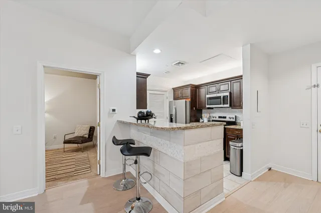 a kitchen with stainless steel appliances kitchen island granite countertop a stove and cabinets