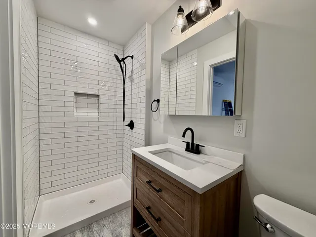 a bathroom with a toilet a sink and mirror
