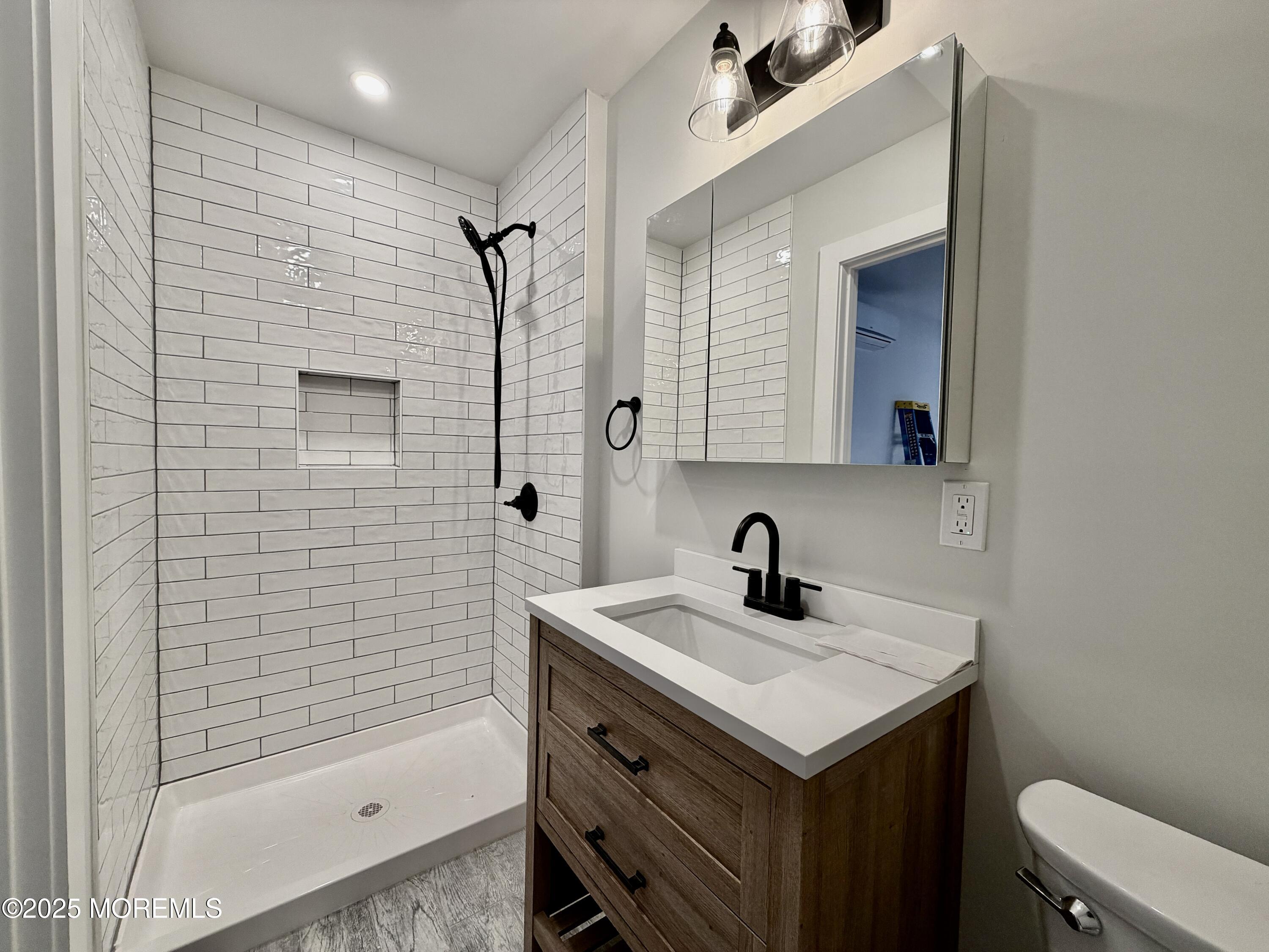 110 4th Avenue, Unit 9 Bradley Beach, NJ 07720 - Photo 7 of 9 a bathroom with a sink a toilet and shower