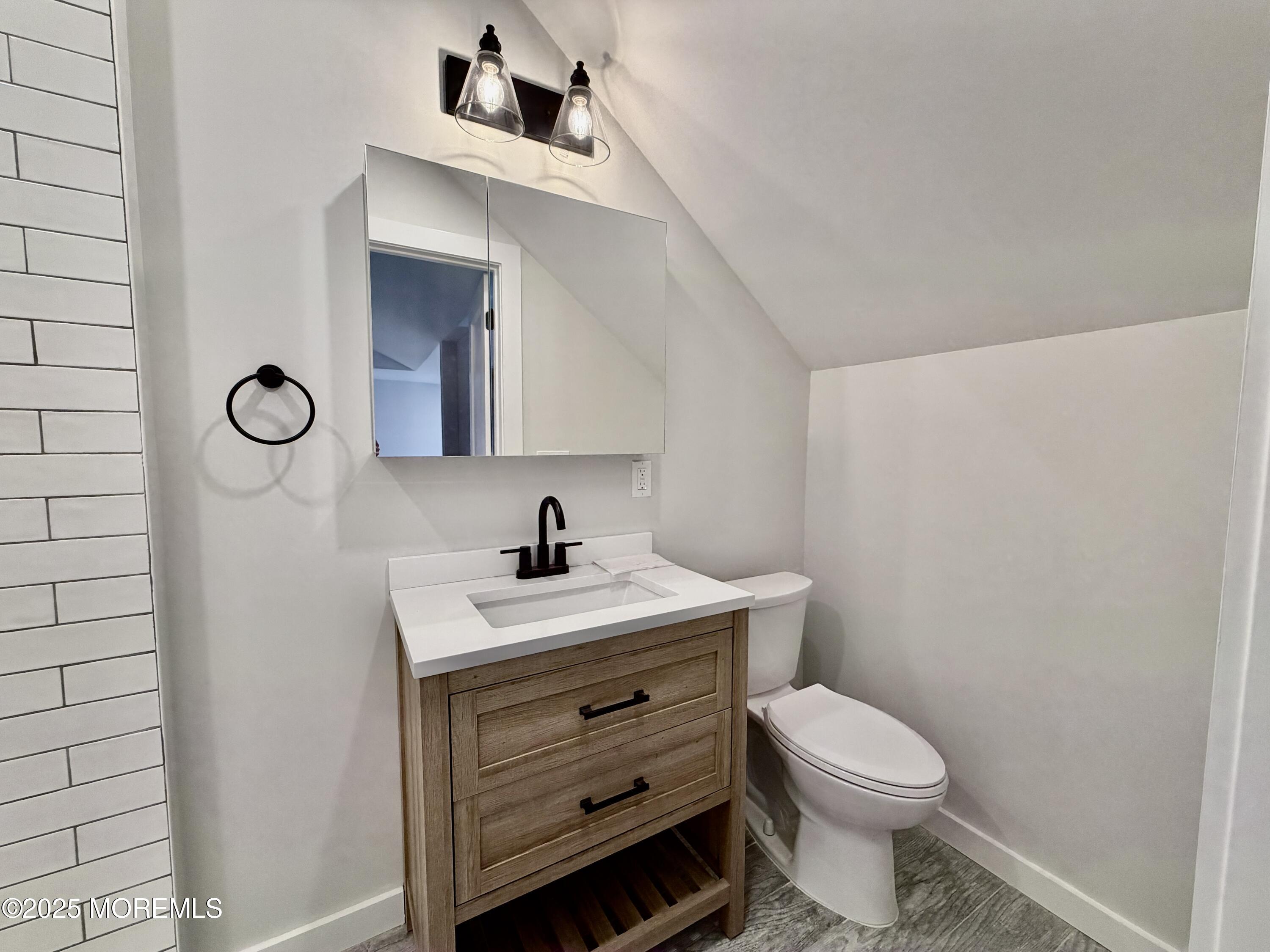 110 4th Avenue, Unit 9 Bradley Beach, NJ 07720 - Photo 8 of 9 a bathroom with a toilet a sink and mirror