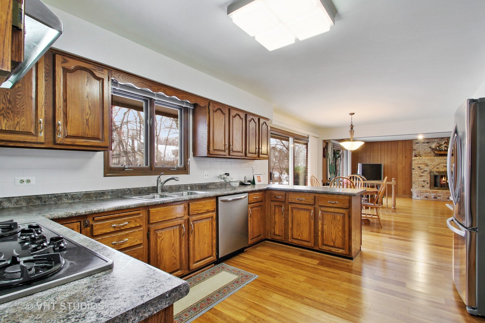 2740 Landwehr Road Northbrook, IL 60062 - Photo 5 of 15 a kitchen with stainless steel appliances granite countertop wooden cabinets a sink dishwasher a stove and a refrigerator with wooden floor