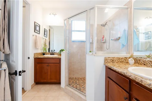 a bathroom with a granite countertop shower sink and mirror