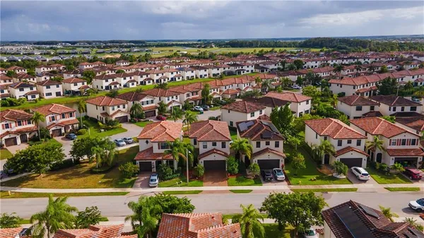 an aerial view of residential houses with outdoor space and trees all around