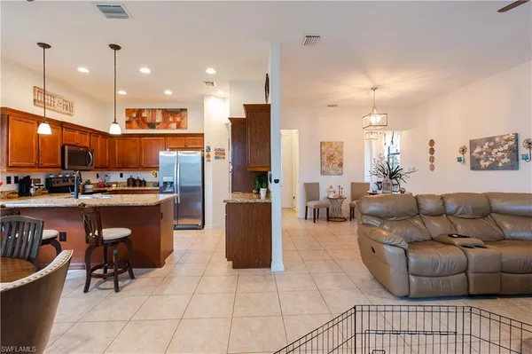 a living room with furniture and a view of kitchen