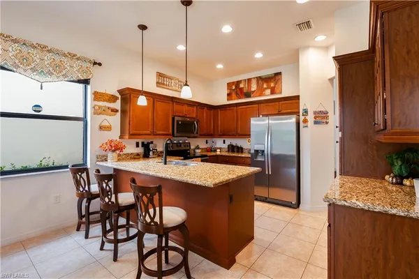 a kitchen with stainless steel appliances granite countertop a refrigerator a sink and a stove