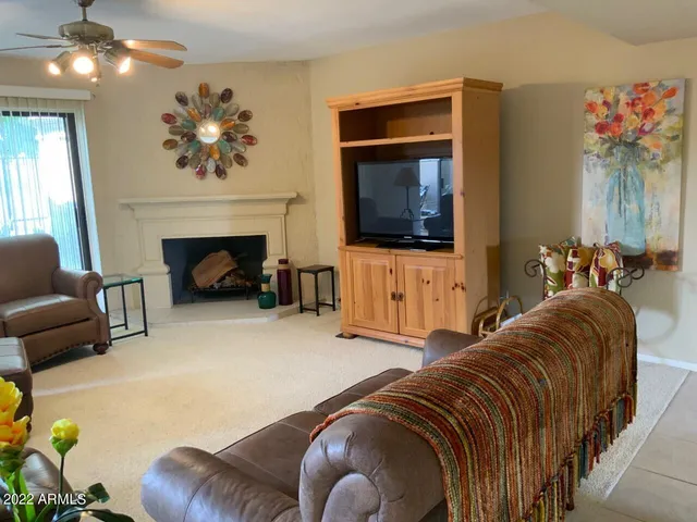 a living room with furniture a fireplace and a flat screen tv