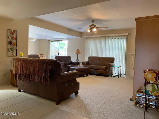 a living room with furniture a ceiling fan and a window