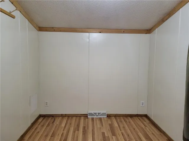 a view of small space with wooden floor and a window