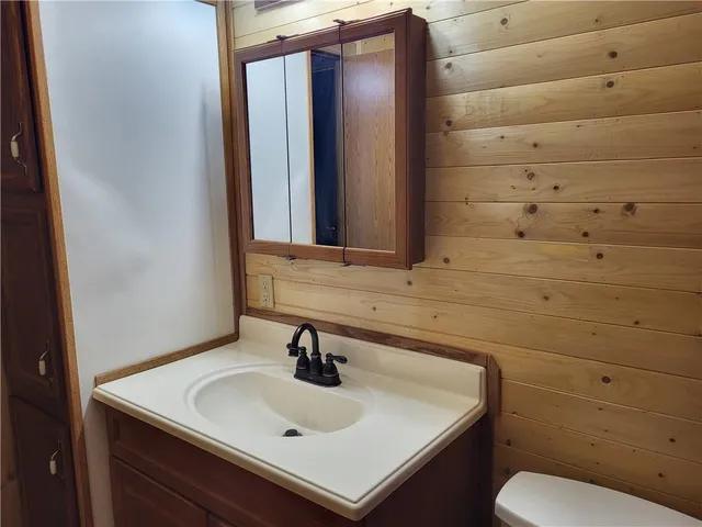 a bathroom with a toilet sink and mirror