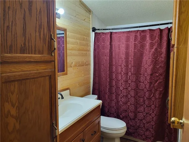a bathroom with a toilet and a shower curtain