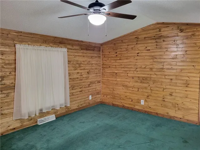 a view of an empty room and chandelier fan
