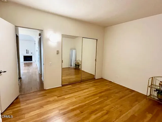 an empty room with wooden floor and entrance