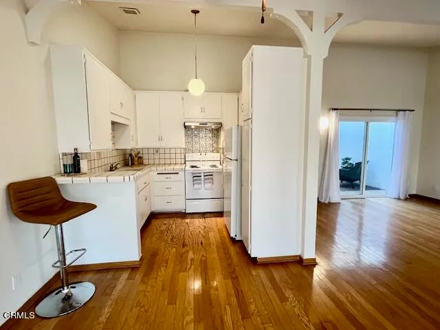 a view of a hallway with wooden floor and a living room