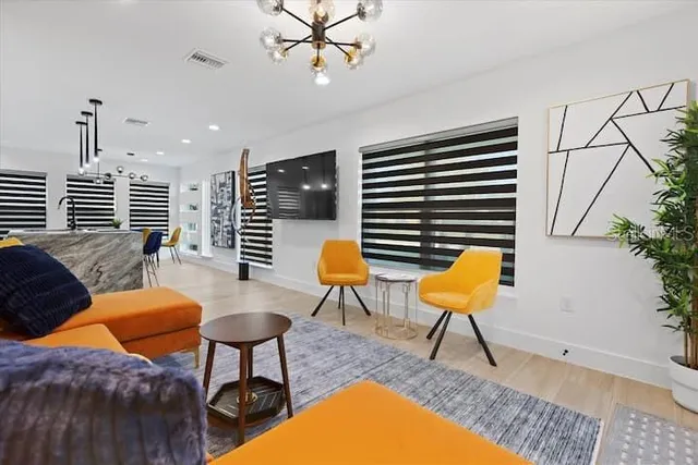 a living room with wooden floor furniture and a ceiling fan