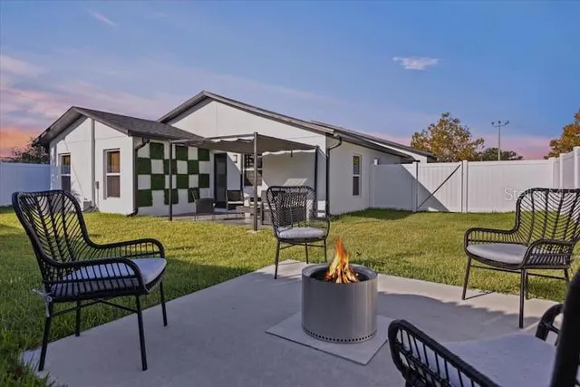 a view of a house with backyard sitting area and garden