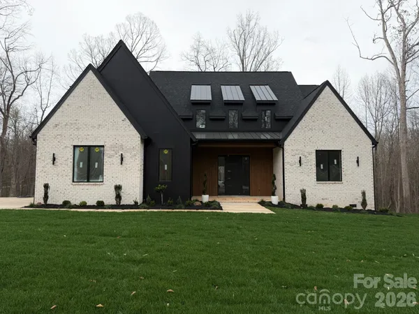 a front view of a house with a garden and yard