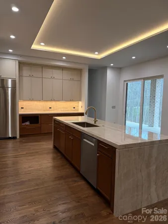 a large kitchen with stainless steel appliances granite countertop a sink and a stove