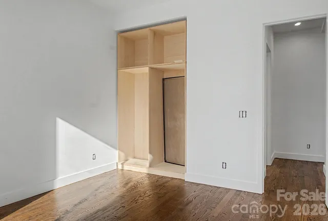 an empty room with wooden floor and closet