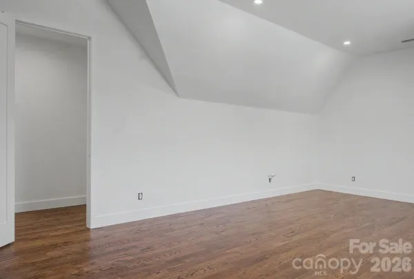 an empty room with wooden floor and window