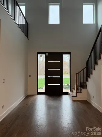 a view of an empty room with stairs and a window