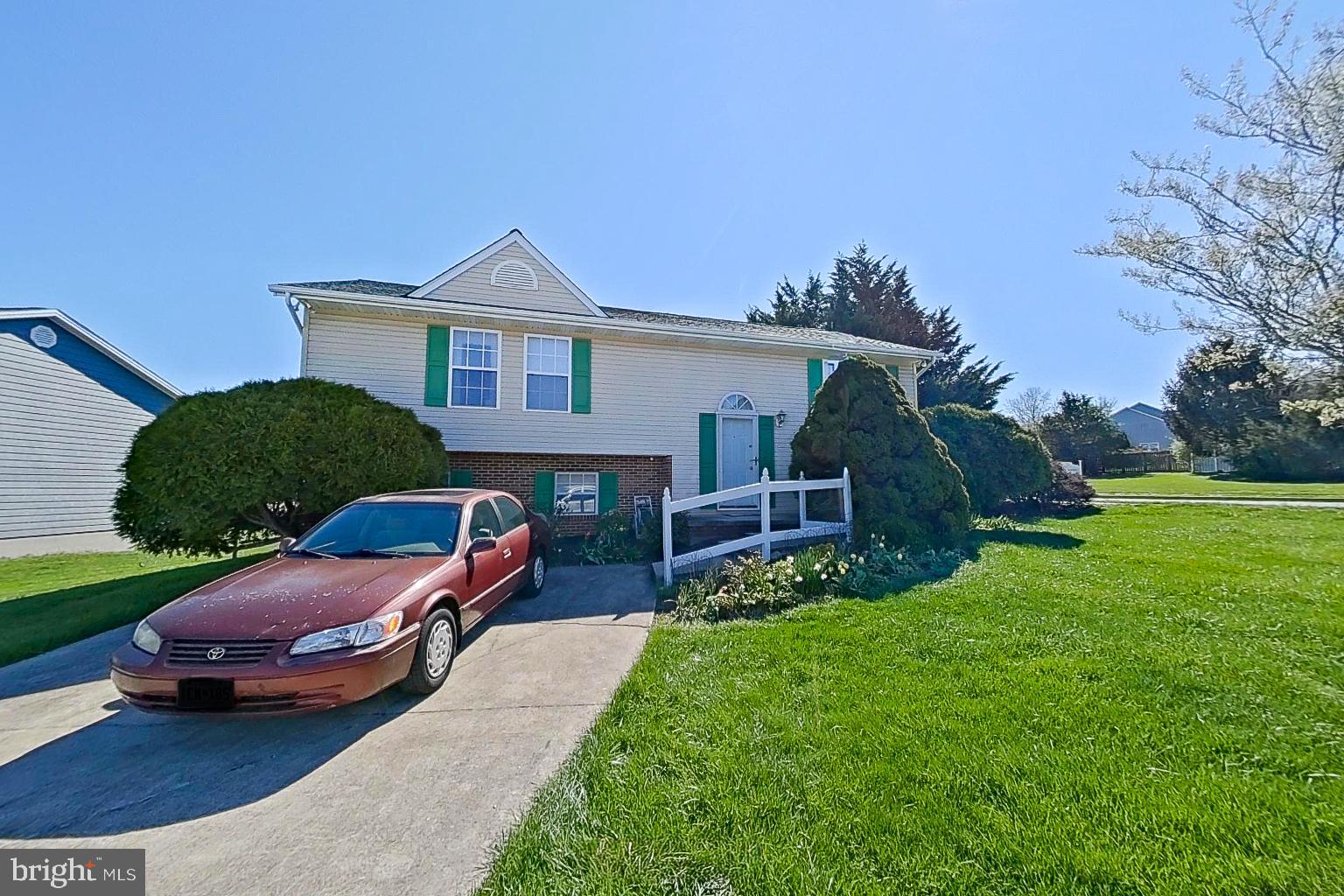 a car parked in front of a house with a yard