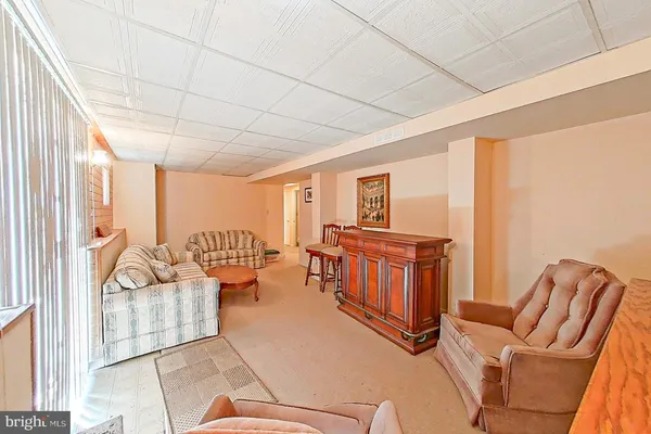 a living room with furniture a flat screen tv and couches with wooden floor
