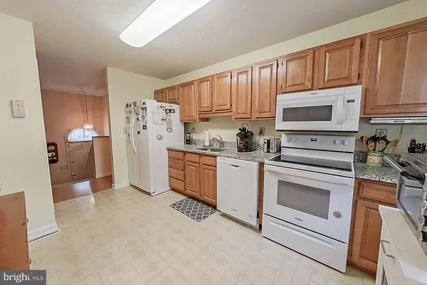 a kitchen with stainless steel appliances white cabinets a stove a sink and a refrigerator