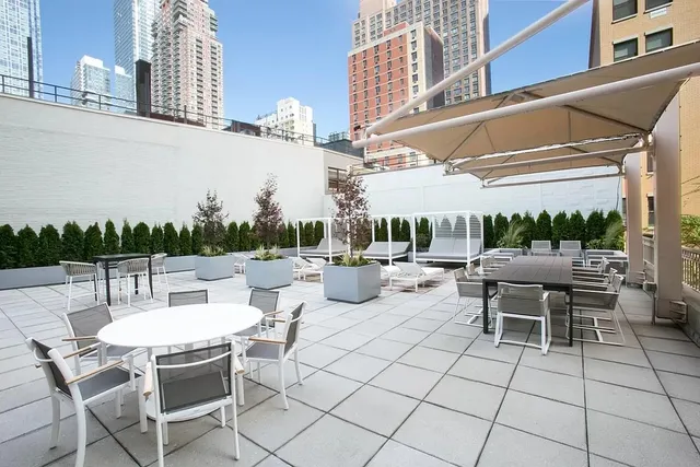 a view of a patio with a table and chairs and potted plants