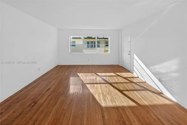 a view of a room with wooden floor and white walls