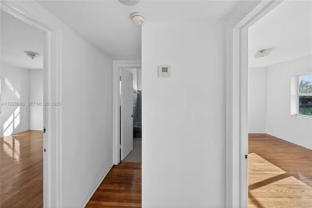 a view of empty room with wooden floor