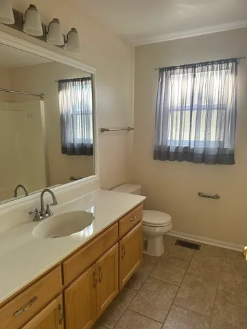 a bathroom with a sink a toilet and mirror
