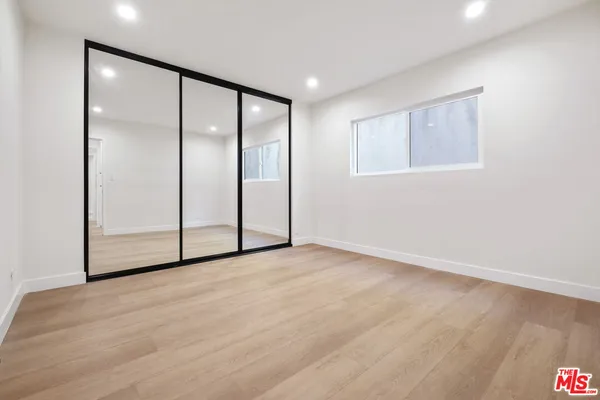 a view of an empty room with closet and a window