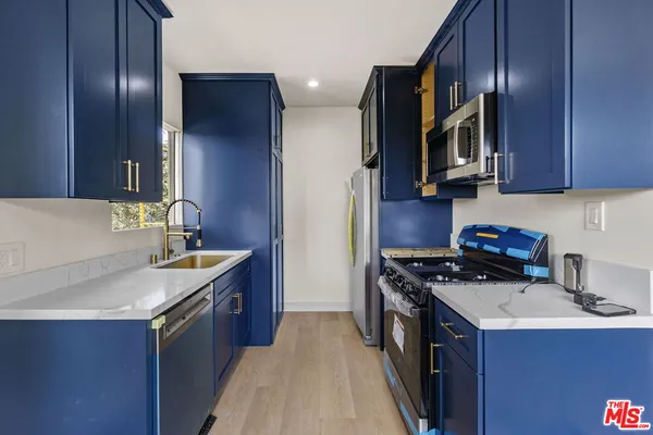 a kitchen with wooden cabinets a sink and stainless steel appliances