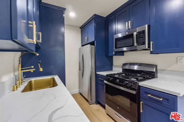 a kitchen with stainless steel appliances granite countertop a stove microwave and refrigerator