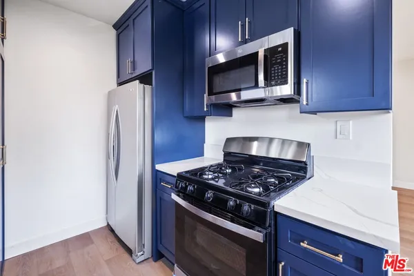 a kitchen with a sink cabinets and wooden floor