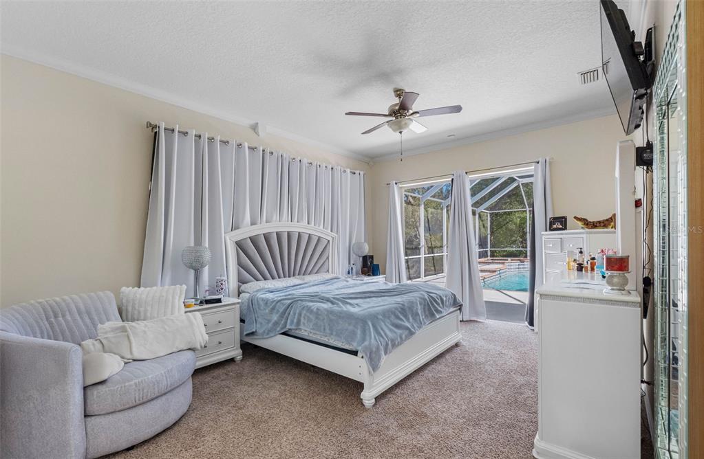 9336 Tooke Shore Drive Weeki Wachee, FL 34613 - Photo 13 of 44 a bedroom with a bed couch and a large window