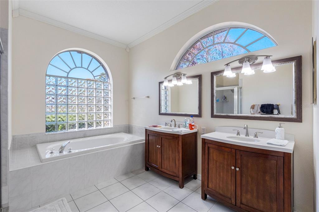 9336 Tooke Shore Drive Weeki Wachee, FL 34613 - Photo 15 of 44 a spacious bathroom with a tub a double vanity sink a mirror a window and a bathtub