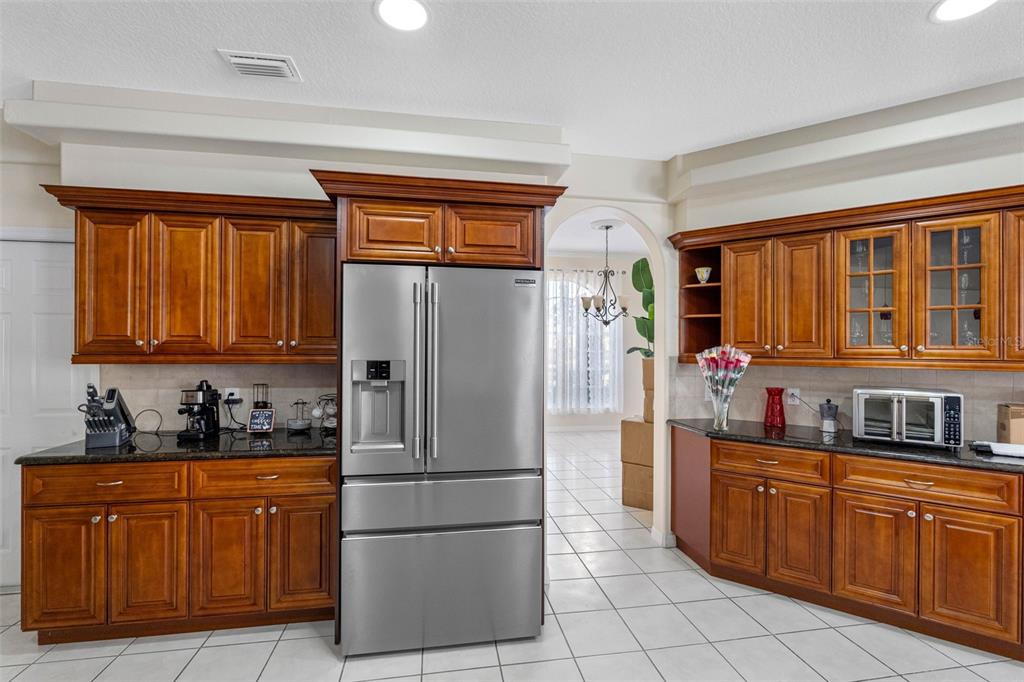 9336 Tooke Shore Drive Weeki Wachee, FL 34613 - Photo 6 of 44 a kitchen with stainless steel appliances granite countertop a refrigerator sink and cabinets
