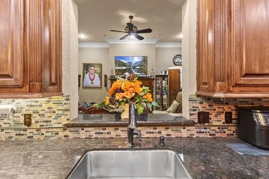 a kitchen with kitchen island granite countertop a sink stainless steel appliances and cabinets