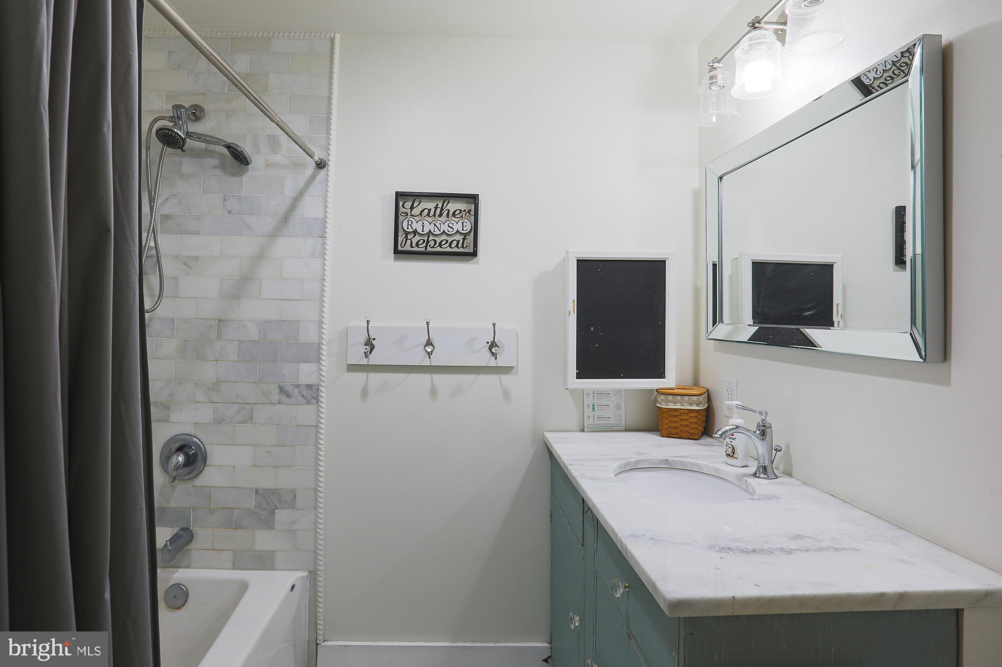 4604 East Joppa Road Perry Hall, MD 21128 - Photo 29 of 56 a bathroom with a sink a mirror and a bathtub
