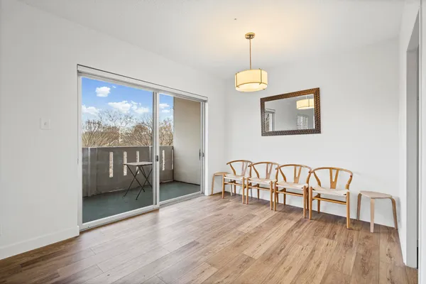 a view of an empty room with window wooden floor