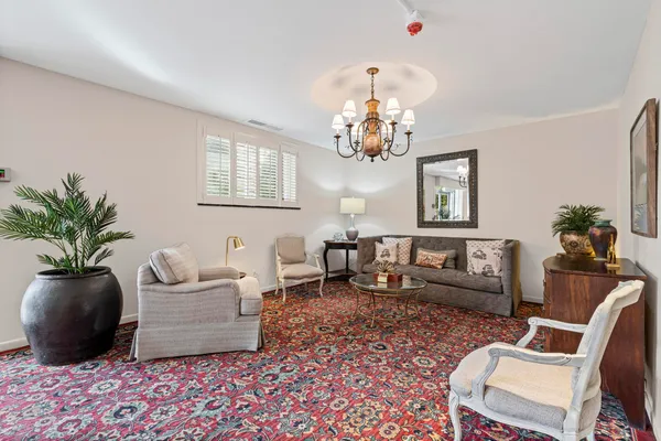 a living room with furniture potted plant and a chandelier