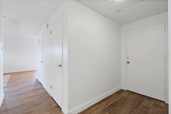 a view of an empty room with wooden floor