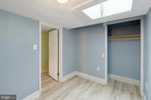 an empty room with wooden floor and closet
