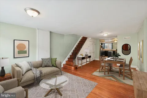 a living room with furniture and wooden floor